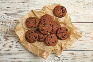 Delicious chocolate chip cookies on wooden table, flat lay