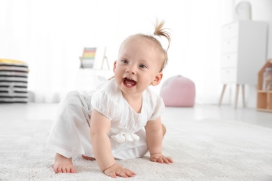 Adorable baby girl in cute clothes at home