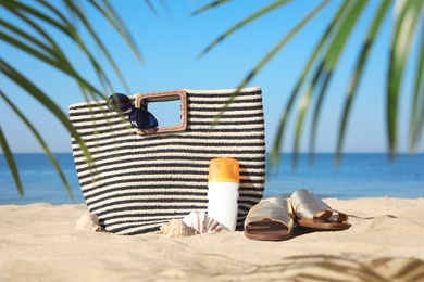 Photo of Stylish beach accessories on sandy sea shore