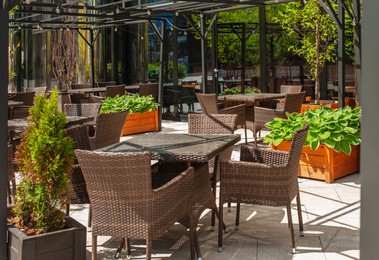 Photo of Beautiful cafe with stylish furniture and plants outdoors