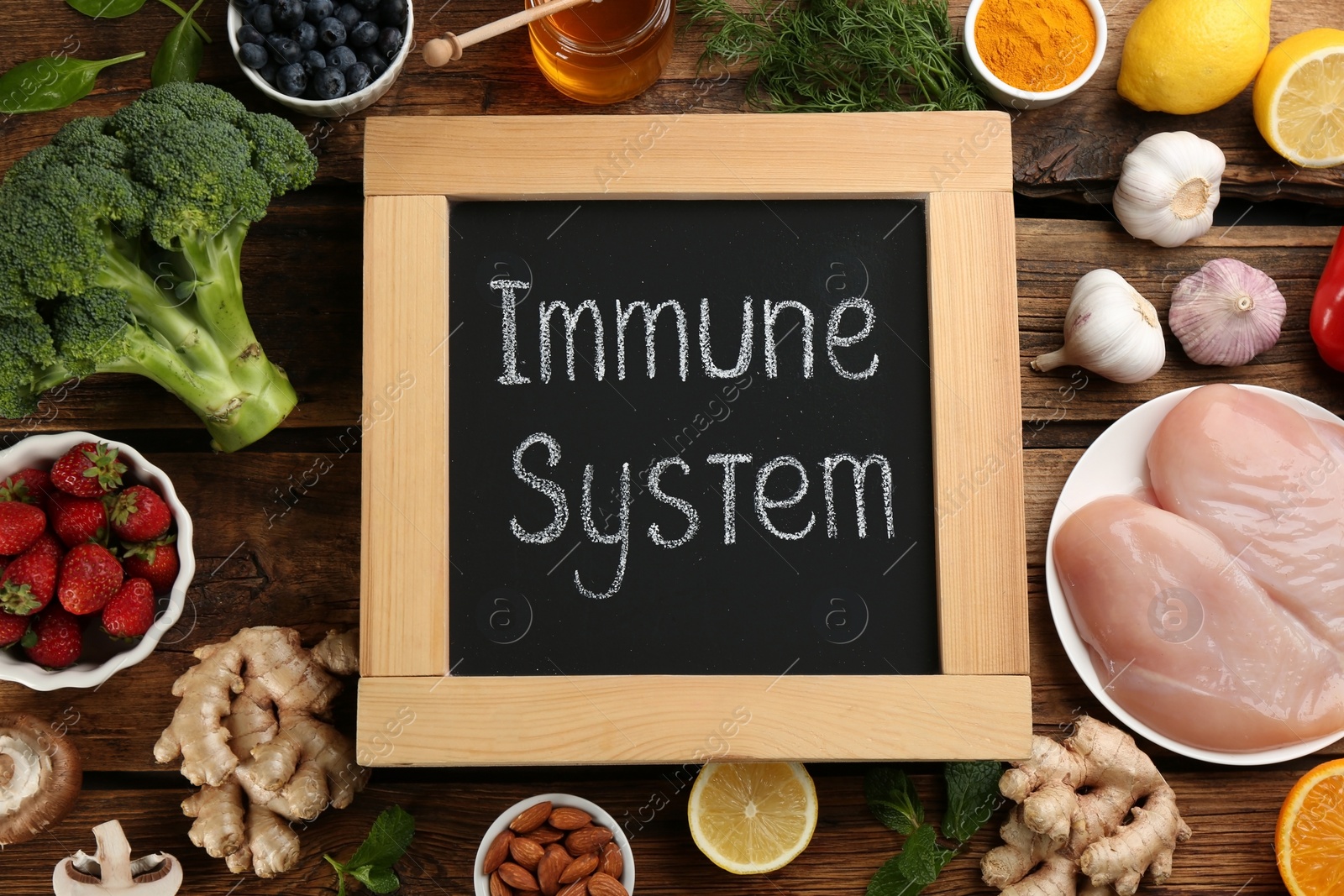 Photo of Chalkboard with phrase Immune System and fresh products on wooden table, flat lay