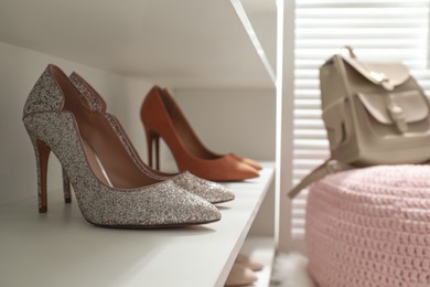 Photo of Storage rack with stylish women's shoes indoors, closeup