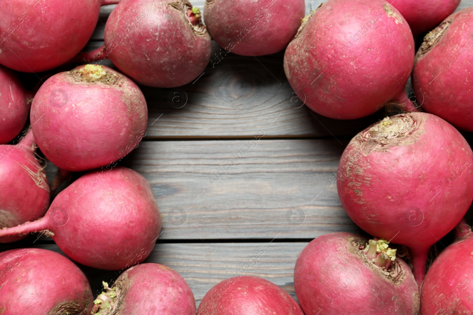 Photo of Frame of red turnips on wooden table, flat lay. Space for text