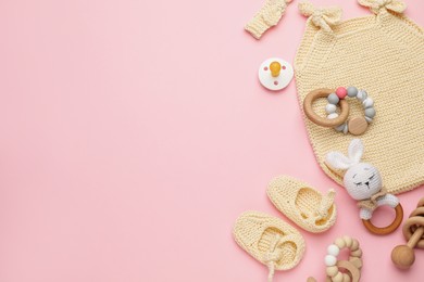 Baby clothes and accessories on light pink background, flat lay. Space for text