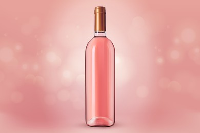 Bottle of expensive rose wine on pink background