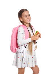 Schoolgirl with healthy food and backpack on white background