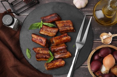 Photo of Tasty roasted pork ribs served on wooden table, flat lay