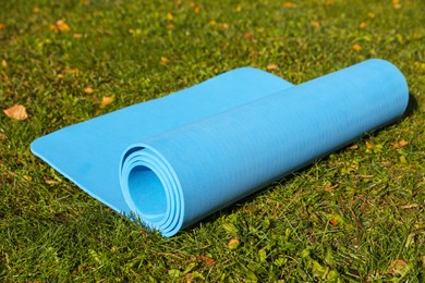 Blue karemat or fitness mat on fresh green grass outdoors