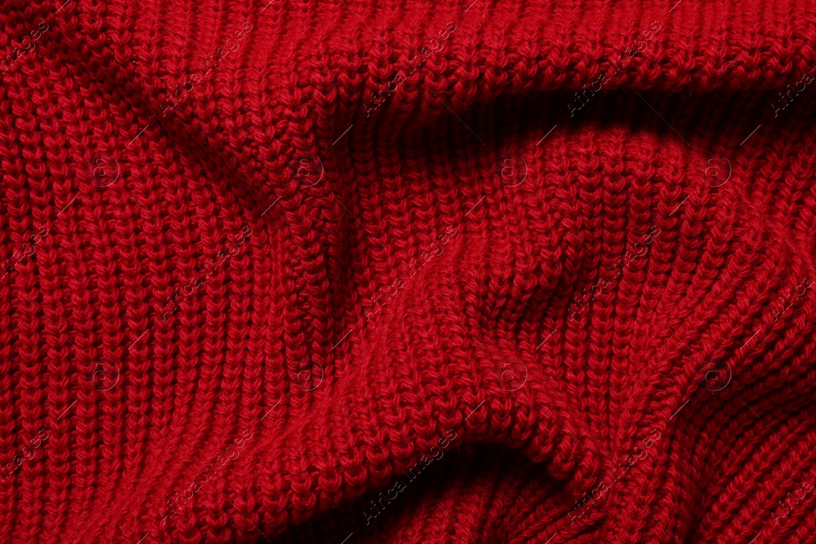 Photo of Texture of soft red knitted fabric as background, top view