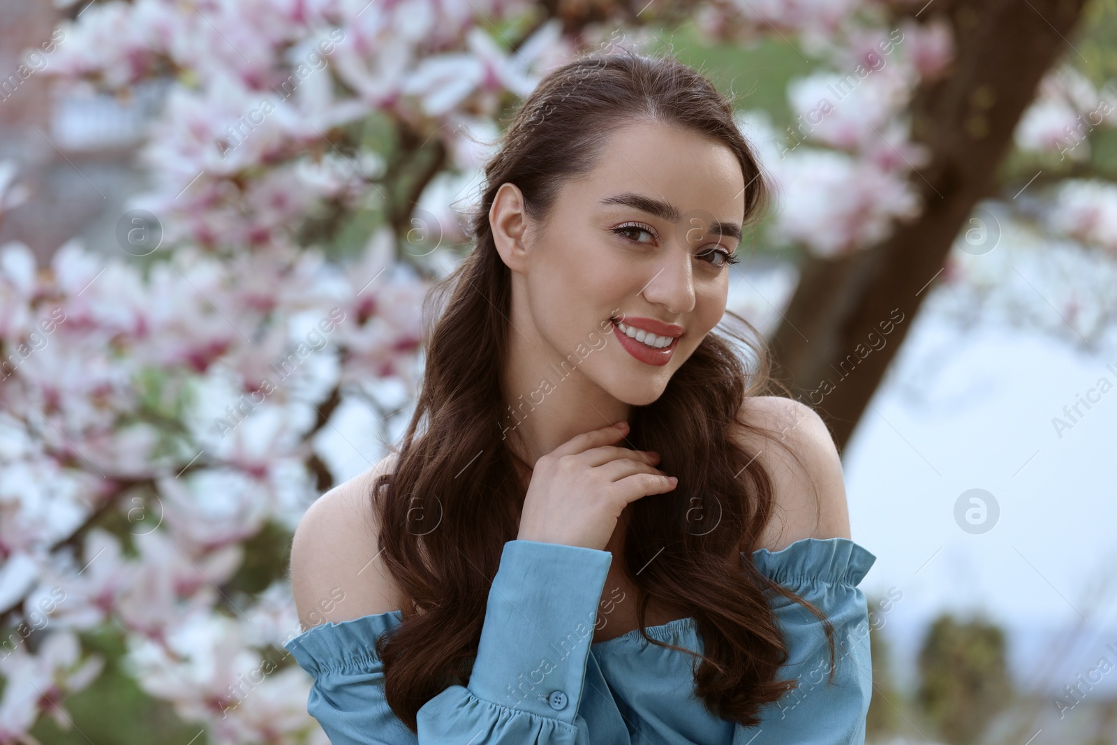 Photo of Beautiful woman near blossoming magnolia tree on spring day