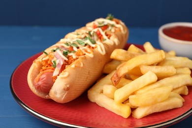 Delicious hot dog with bacon, carrot and parsley served on blue wooden table, closeup