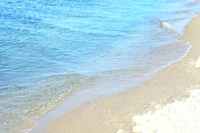 Photo of View of sea water and beach sand on sunny day