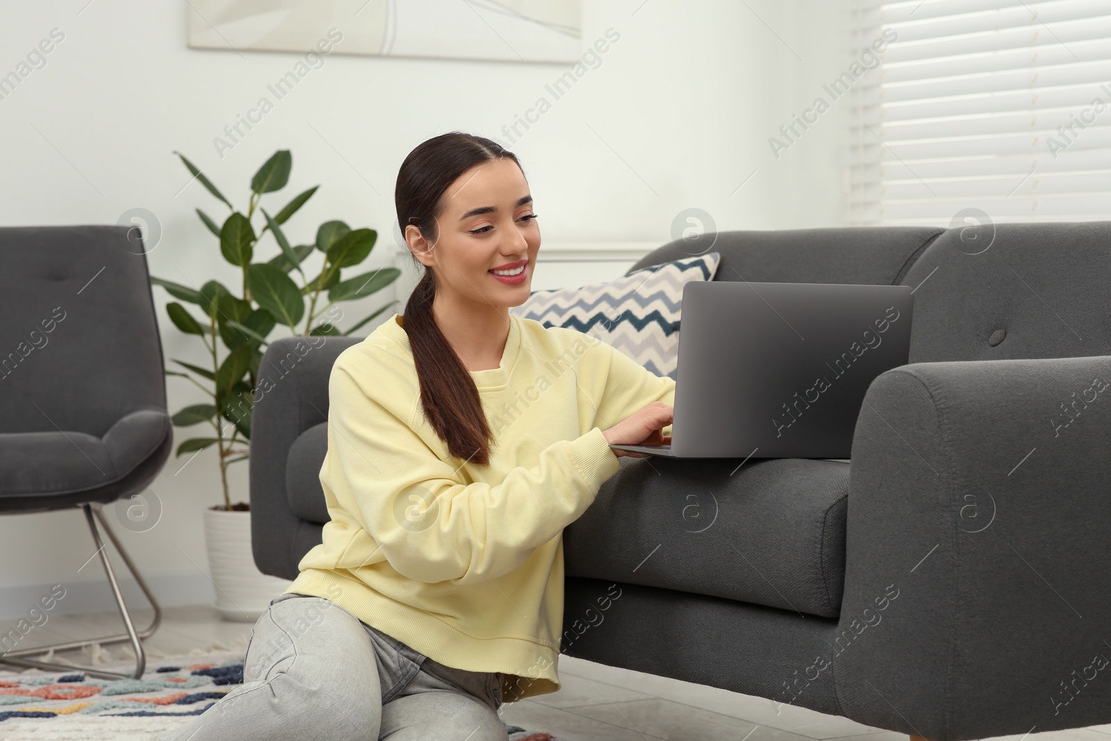 Photo of Woman using laptop on couch at home