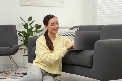 Woman using laptop on couch at home