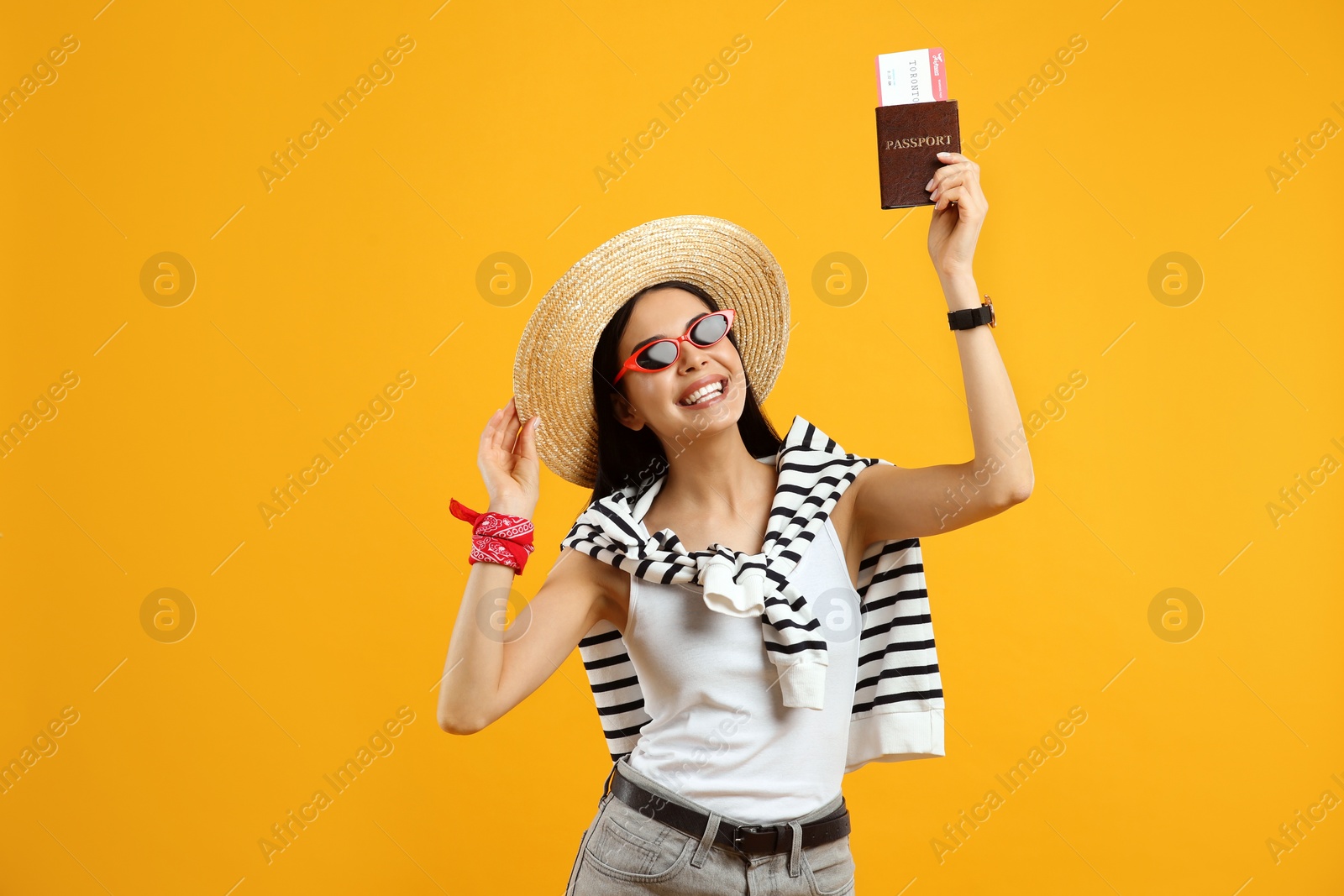 Photo of Happy female tourist with ticket and passport on yellow background