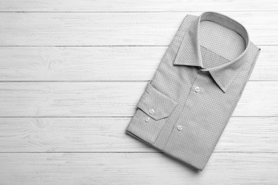 Male stylish grey shirt on white wooden background, top view. Space for text