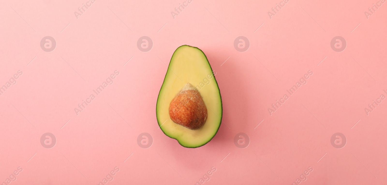 Image of Half of delicious avocado on pink background, top view. Banner design