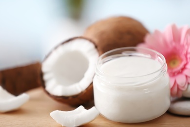 Composition with coconut butter in glass jar on blurred background