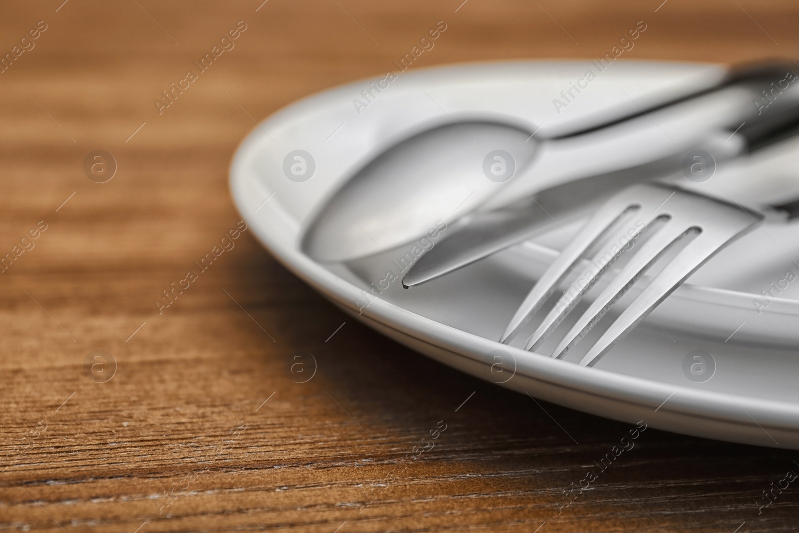 Photo of Empty dishware and cutlery on wooden table, close up view. Table setting