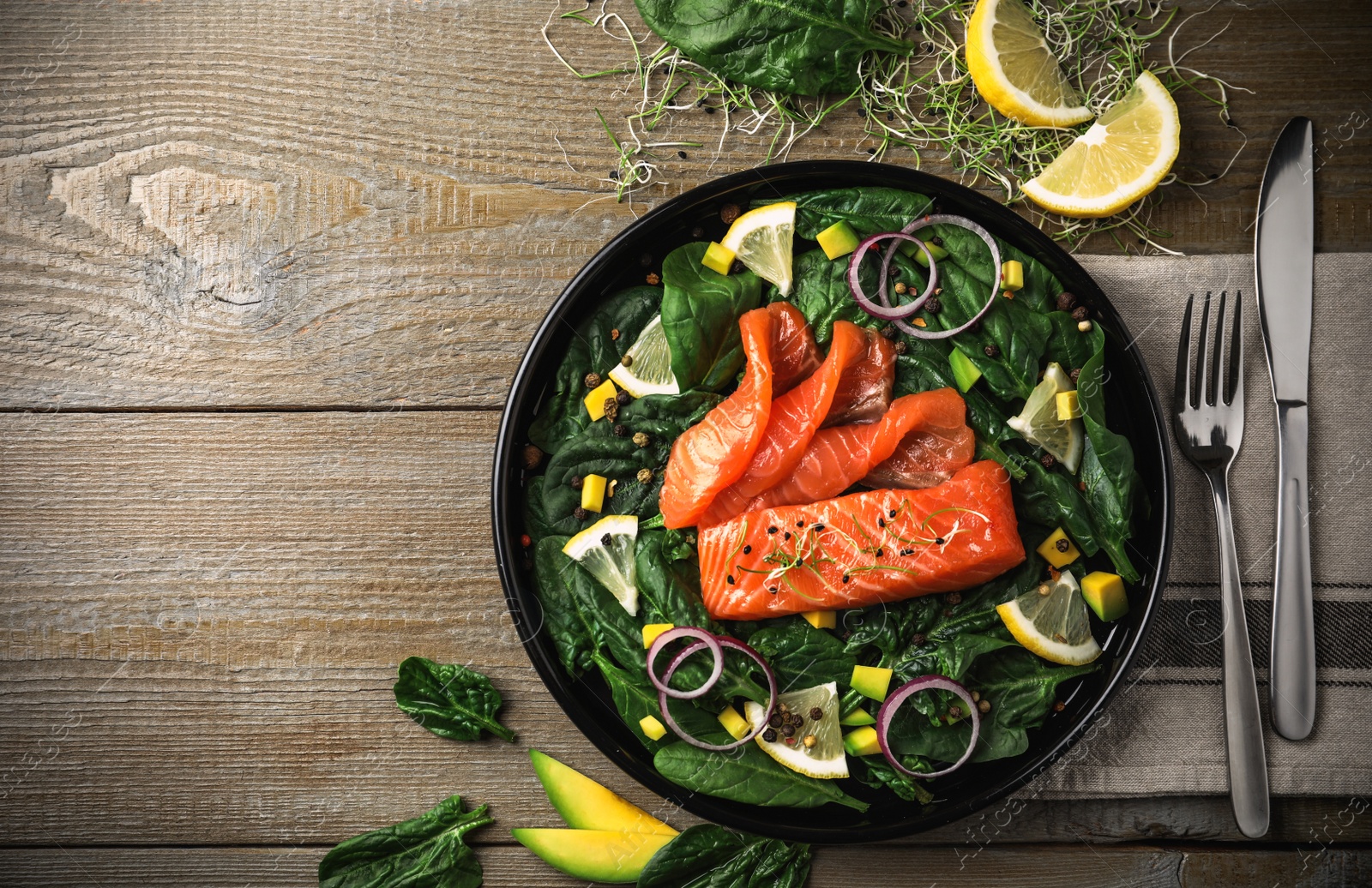 Image of Delicious salmon with spinach and avocado served on wooden table, flat lay. Food photography  