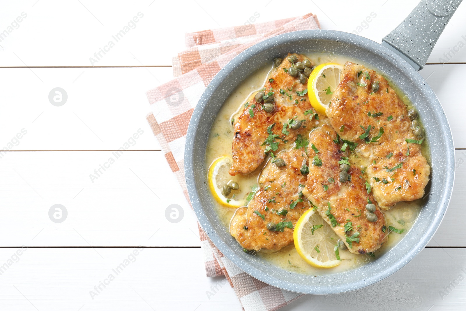 Photo of Delicious chicken piccata on white wooden table, top view. Space for text