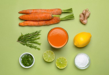 Photo of Flat lay composition with healthy carrot juice in glass and ingredients on light green background