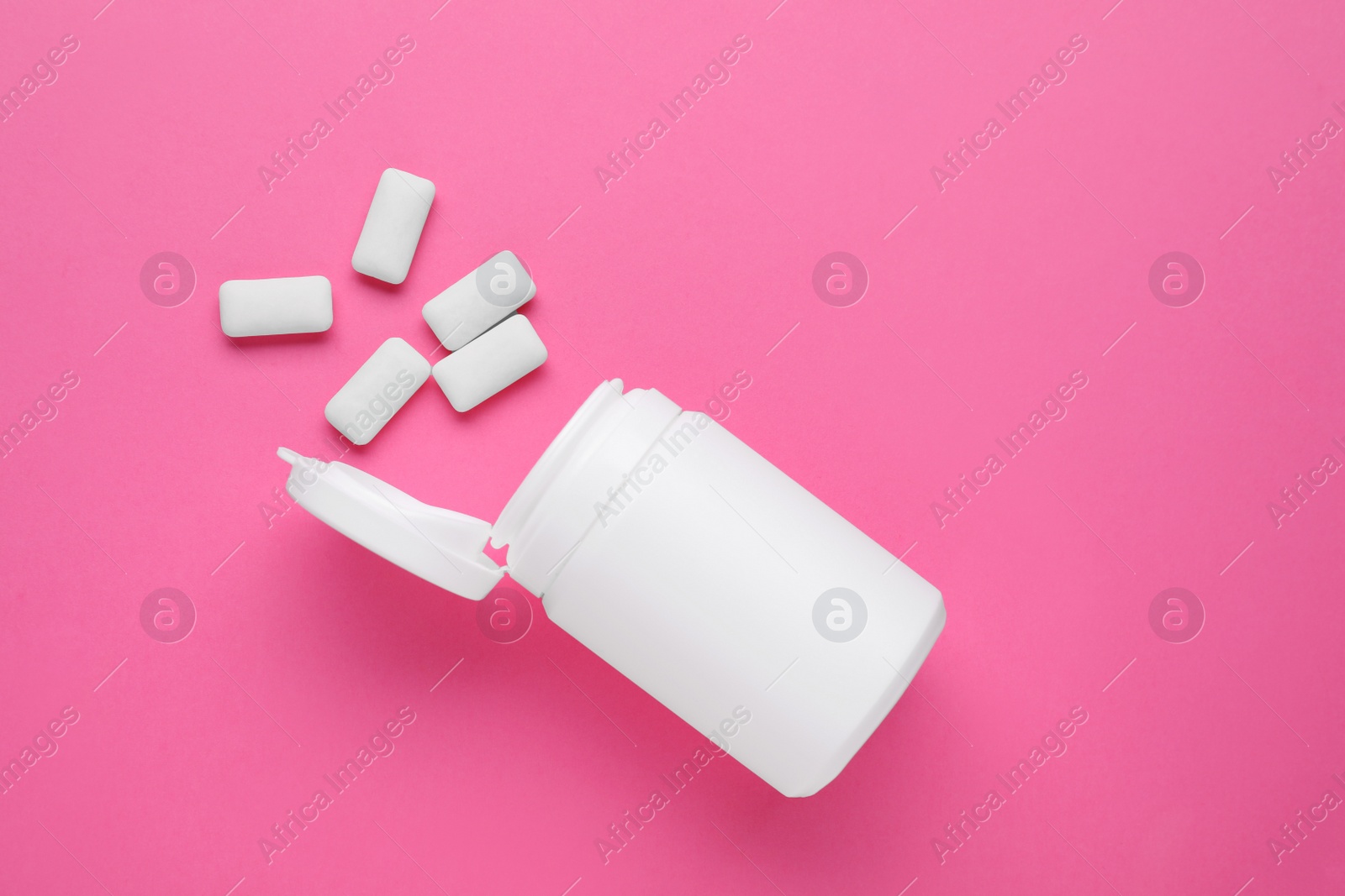 Photo of Jar with chewing gums on pink background, flat lay