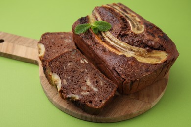 Photo of Delicious banana bread with mint on green background, closeup