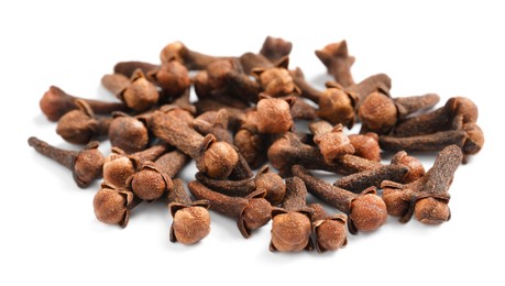 Pile of aromatic dry cloves on white background