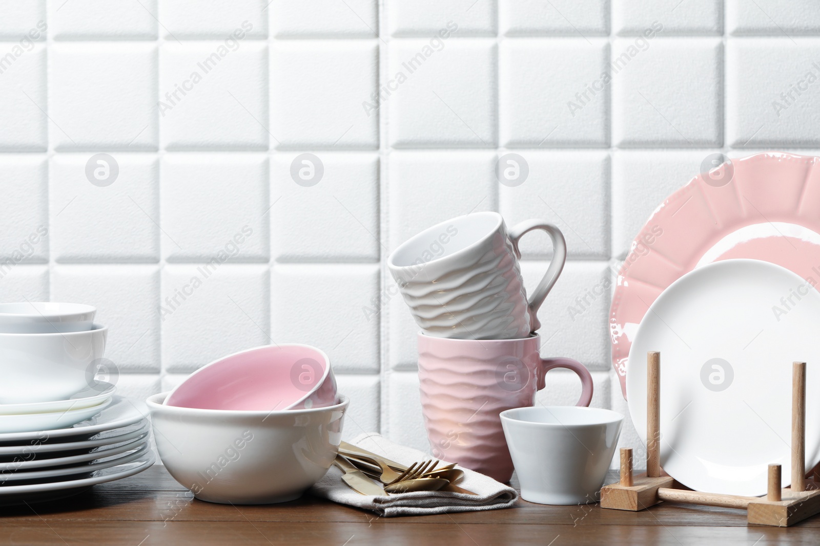 Photo of Beautiful ceramic dishware, cups and cutlery on wooden table