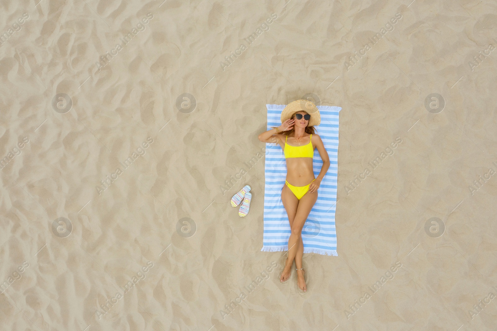 Image of Woman sunbathing on beach towel at sandy coast, aerial view. Space for text