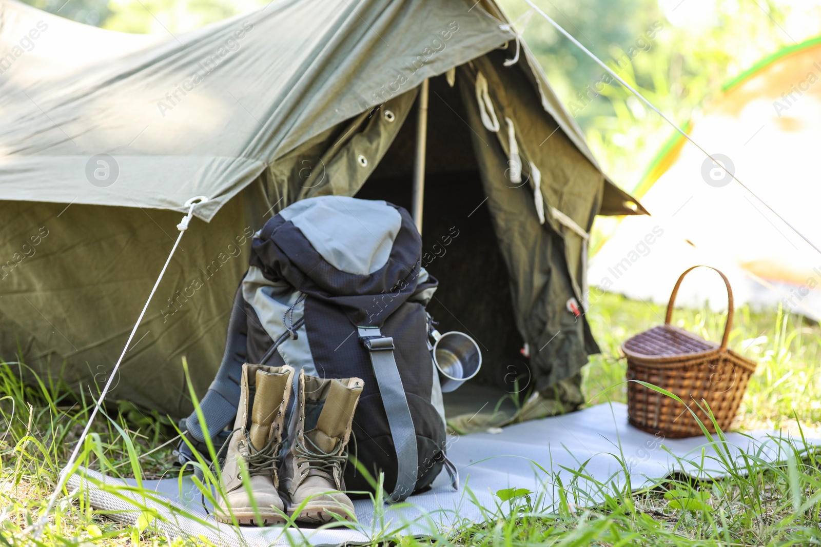 Photo of Traveling gear near tent outdoors. Summer camp