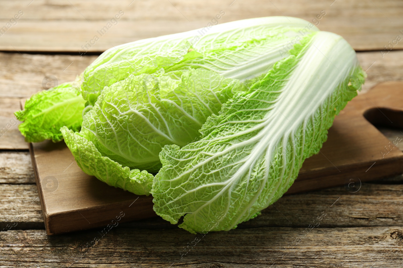 Photo of Fresh ripe Chinese cabbage on wooden table, closeup