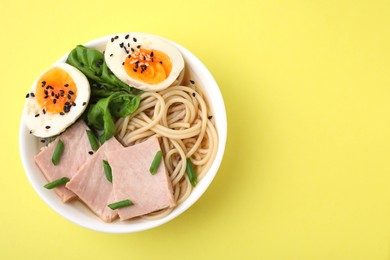 Photo of Delicious ramen with meat on pale yellow background, top view. Noodle soup. Space for text