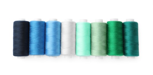 Photo of Set of different colorful sewing threads on white background, top view