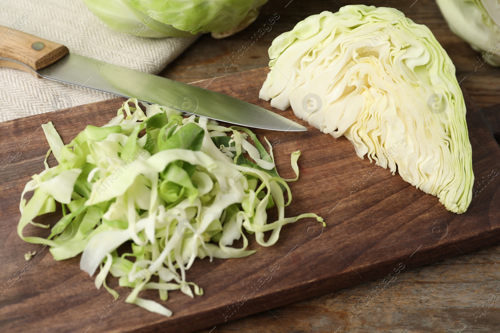 Photo of Chopped ripe cabbage on wooden table, closeup