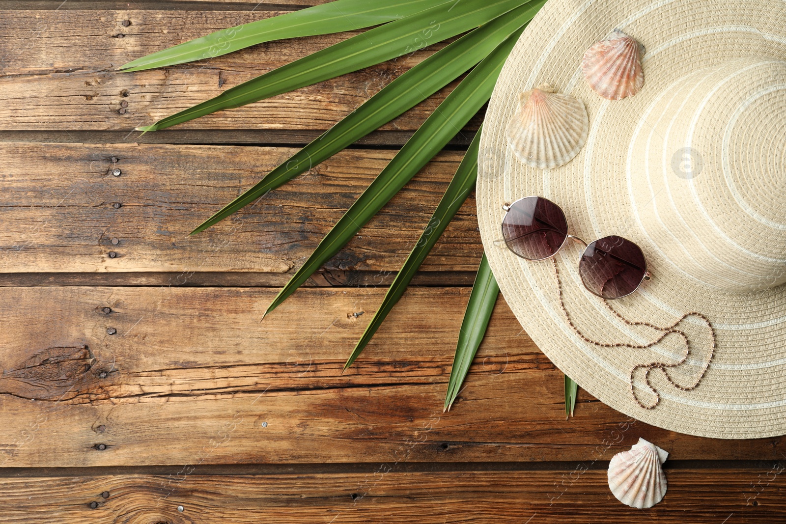 Photo of Flat lay composition with hat on wooden background. Beach objects