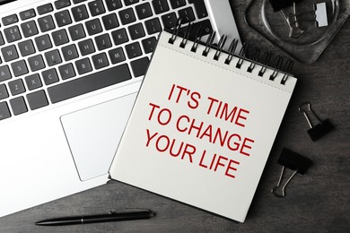 Image of Notebook with phrase It's Time to Change Your Life and laptop on grey table, flat lay