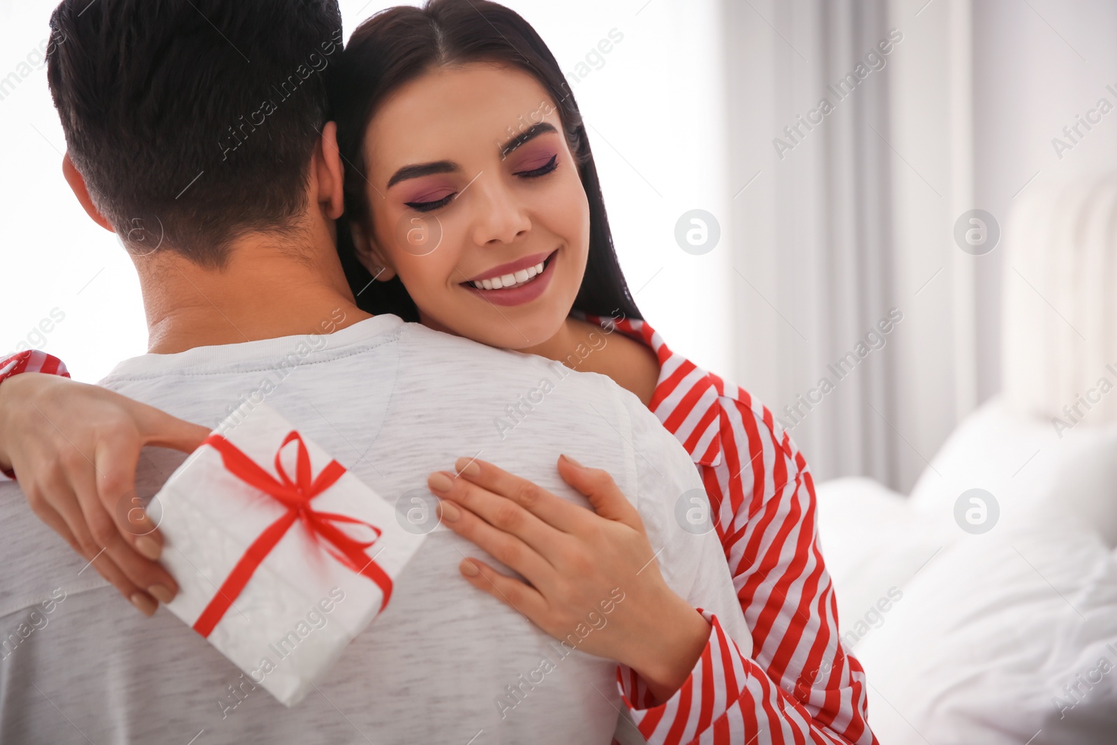 Photo of Lovely couple with gift box at home. Valentine's day celebration