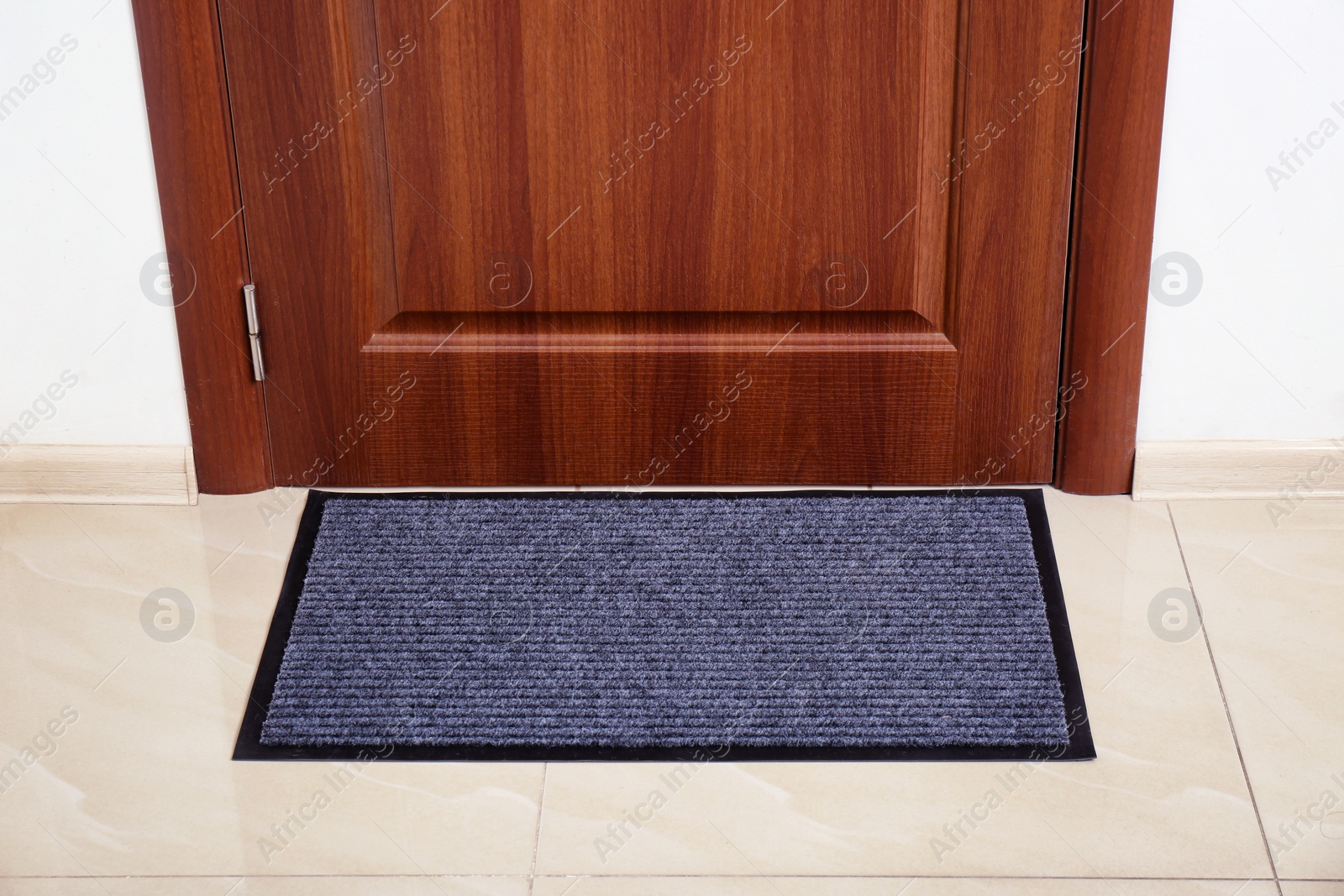 Photo of Modern welcome mat at door in hall