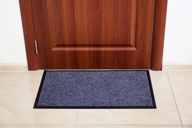 Modern welcome mat at door in hall