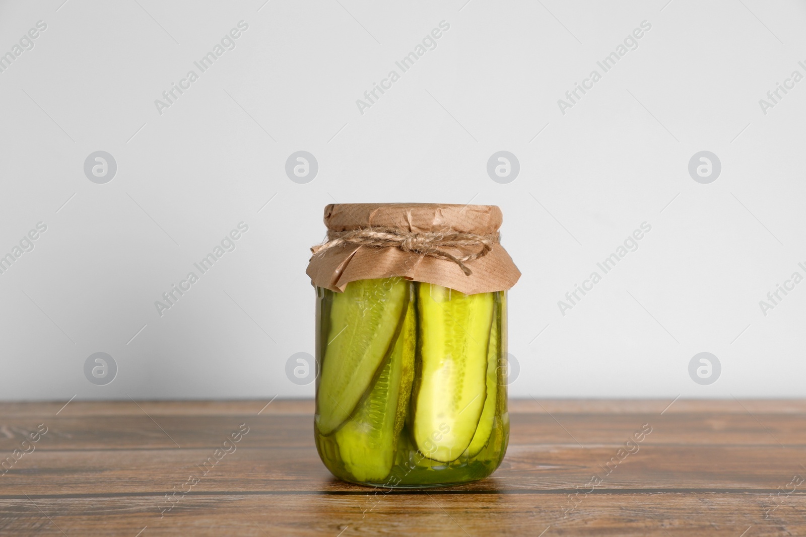 Photo of Jar with pickled cucumbers on wooden table