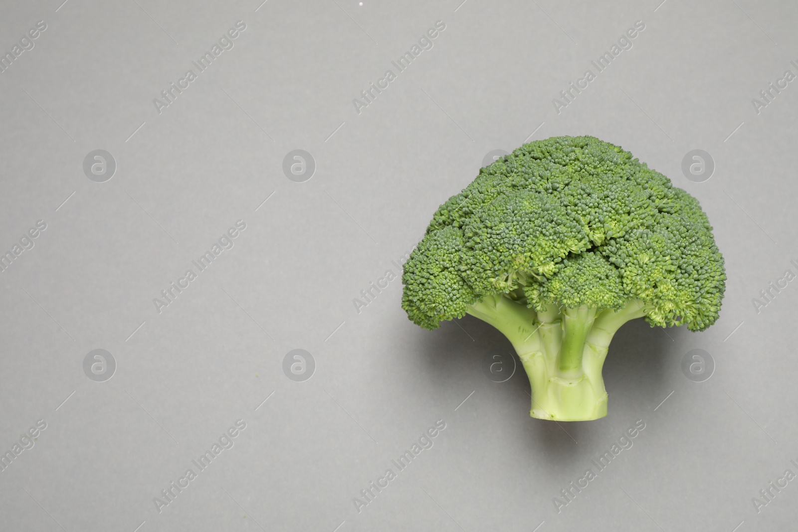 Photo of Fresh tasty broccoli on grey background, top view. Space for text