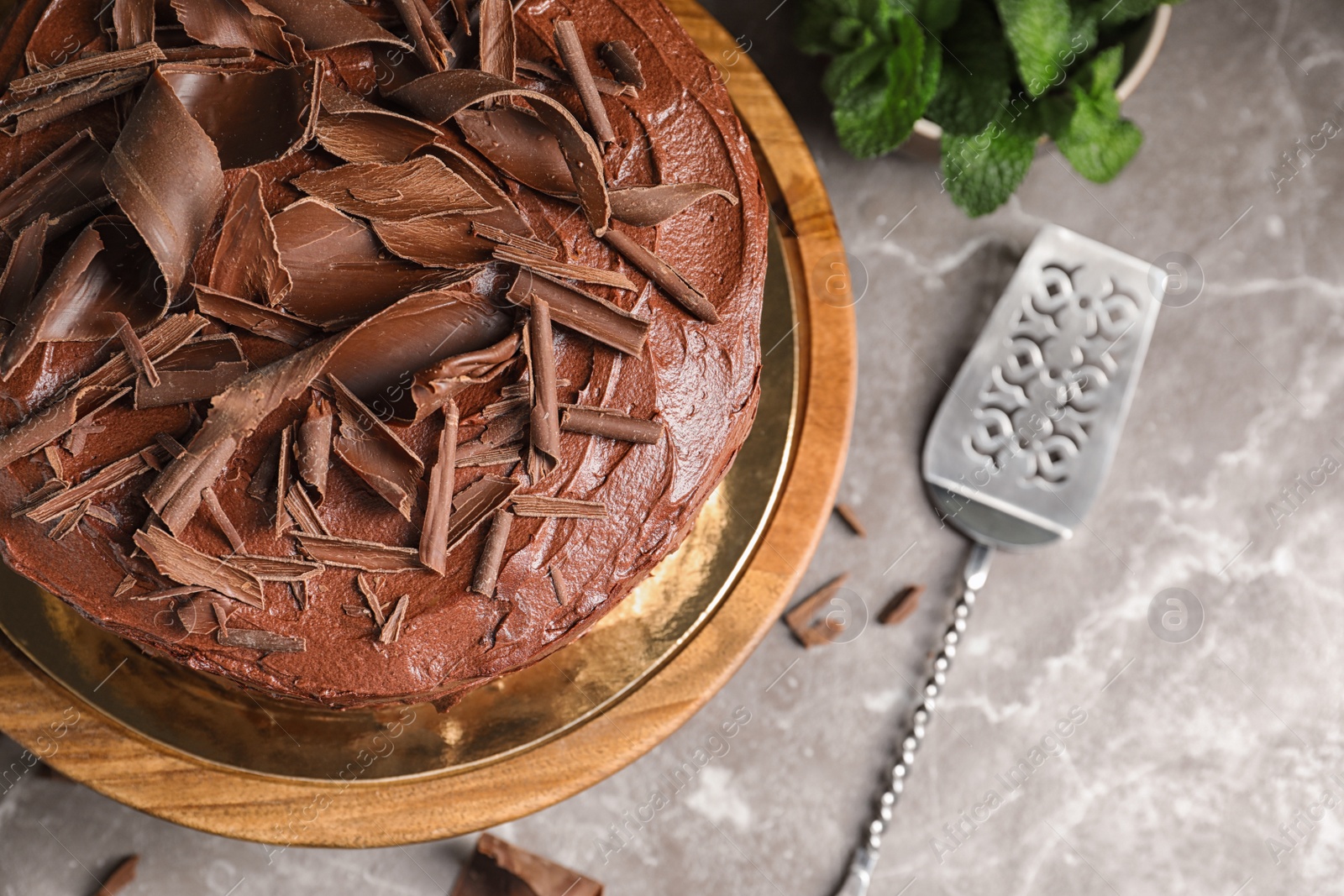 Photo of Tasty chocolate cake and shovel on table, top view. Space for text