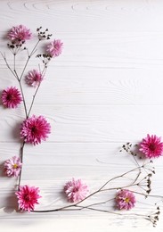 Photo of Flat lay composition with beautiful flowers on white wooden table, space for text