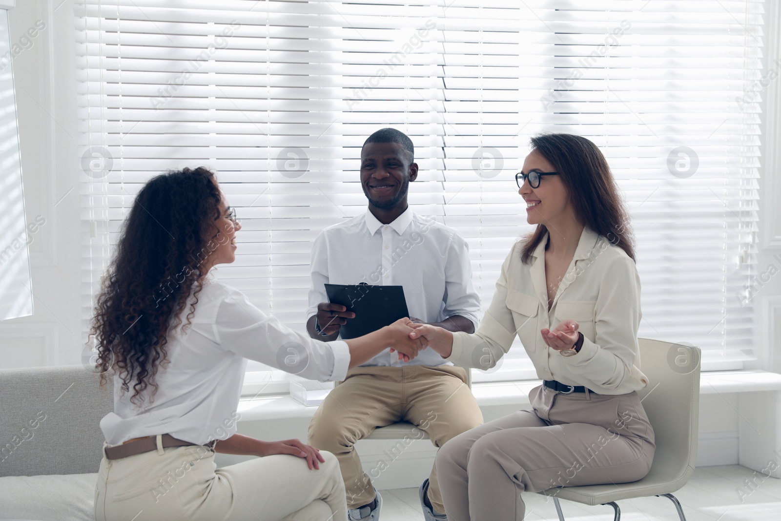 Photo of Boss shaking hands with new coworker during job interview in office