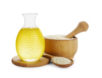 Photo of Glass bottle of fresh sesame oil and seeds isolated on white