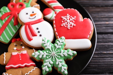 Photo of Delicious Christmas cookies on black wooden table table, closeup