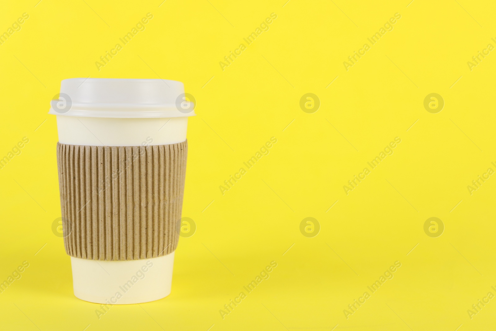 Photo of Paper cup with plastic lid on yellow background, space for text. Coffee to go