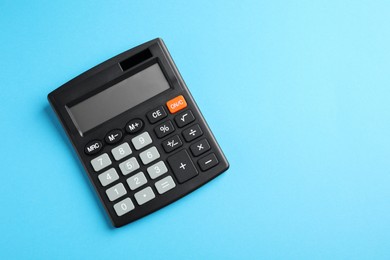 Calculator on light blue background, top view. Space for text